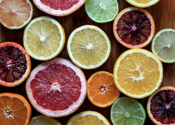 Picture of different color citric fruits, sliced in half.