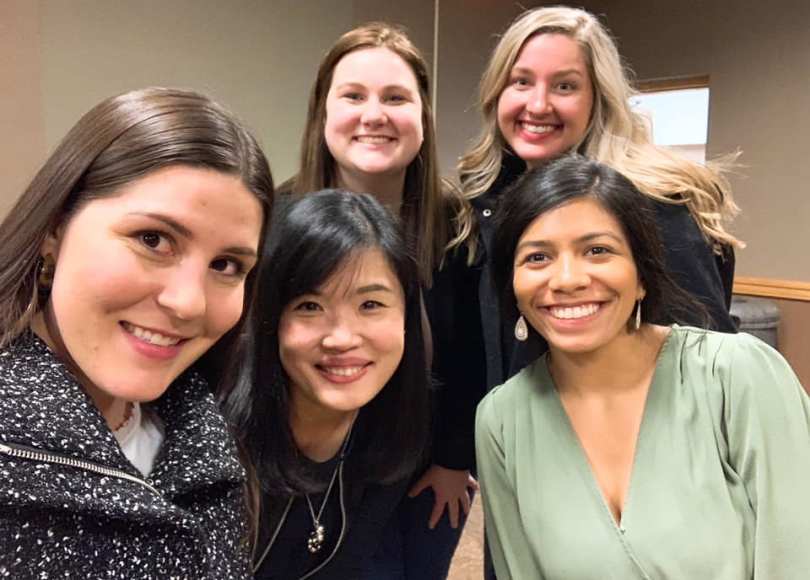 Five women smile at camera