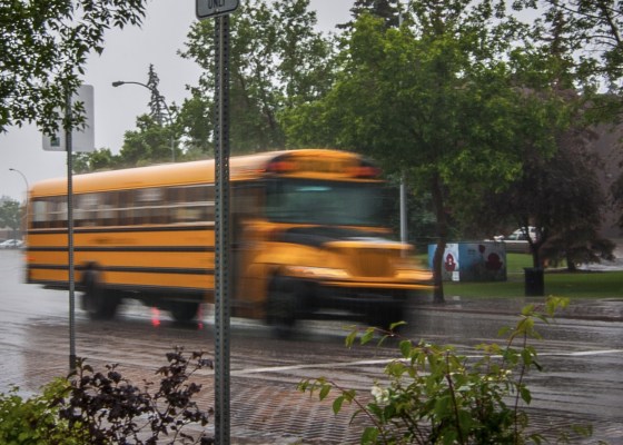 Yellow school bus on road during rain