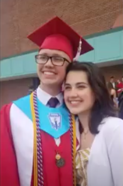 Smiling man and woman, posing for a picture, man wearing red graduation robes